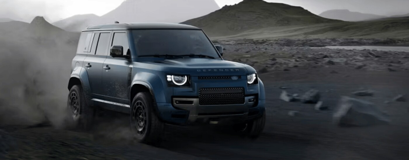 2026%20Land%20Rover%20Defender%20Ocha%20-%20trail.png Blue 2026 Land Rover Defender Ocha driving down a dusty trail