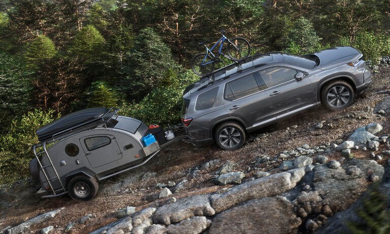 2023 Honda Pilot towing a camper up a mountain