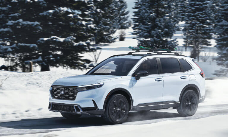 2023 Honda CR-V driving through a snowy forest