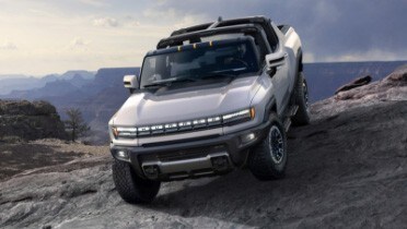 gmc_white_hummer_ev_driving_on_slanted_dirt_hill.jpeg