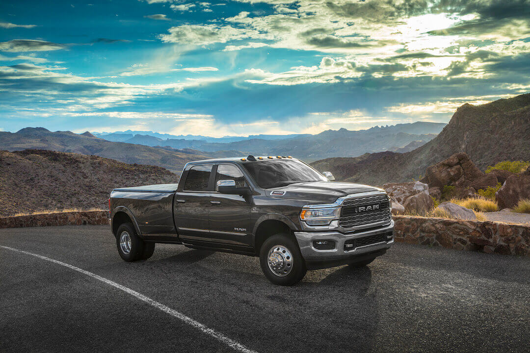 Vue latérale 3/4 avant d'un RAM 3500 HD Limited 2019 garé sur une route au bord des montagnes