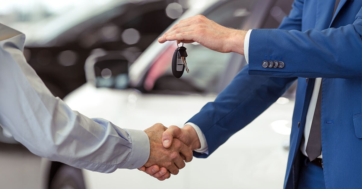 shaking hands at the dealership after a successful pre-owned vehicle purchase