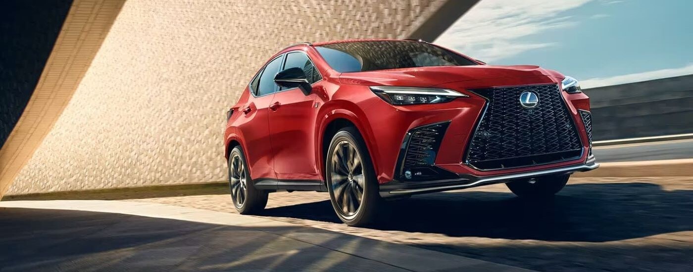 Red used 2024 Lexus NX for sale driving around a bend.