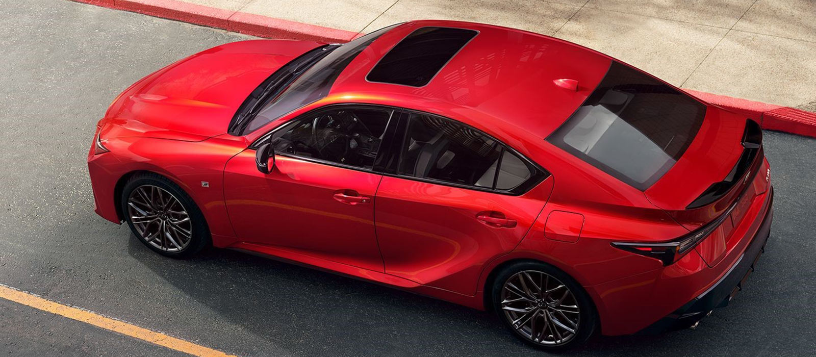 2025 Lexus IS Trim Comparison Red 2025 Lexus IS parked on a city street