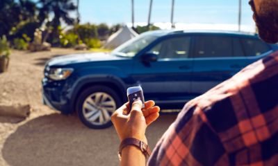 VW Atlas Man holding a key outside of a blue VW Atlas