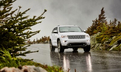 Jeep Grand Cherokee Overland white Jeep Grand Cherokee Overland driving outside in the rain