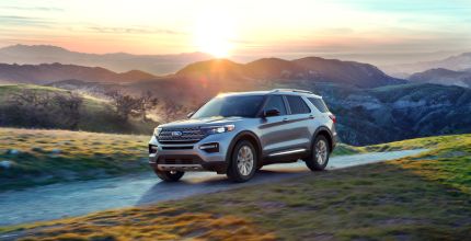 Ford Explorer gray Ford Explorer on a dirt road with mountains in the background