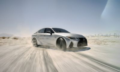 Lexus IS silver Lexus IS making a quick turn while driving on a dusty road