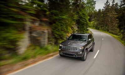 Jeep Grand Cherokee Overland gray Jeep Grand Cherokee Overland driving on the road