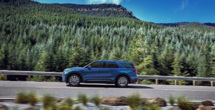 Ford Explorer blue Ford explorer on the road with mountain and trees in the background