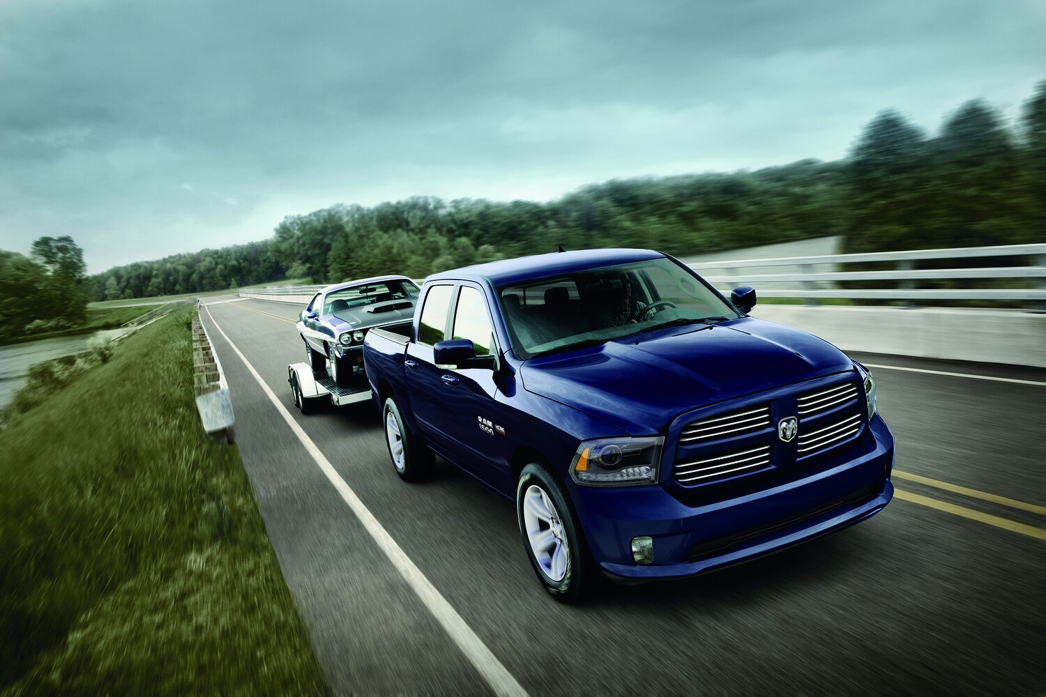 2016-RAM-1500-Express-HFE-Crew-Truck-L01.png blue Ram 1500 truck towing a Dodge Charger