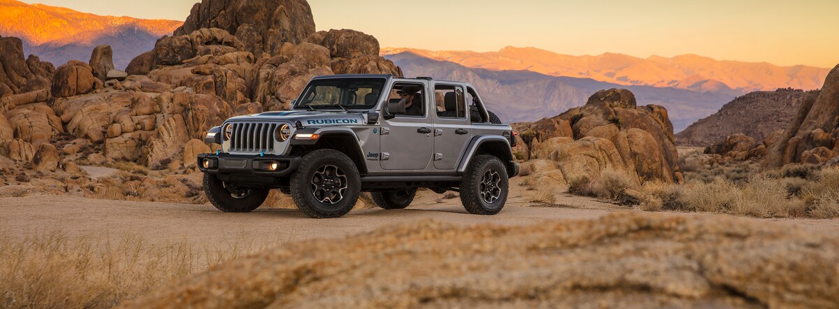 2022-Jeep-Wrangler-4XE-Rubicon-4x4-SUV-L05.2.png silver Jeep Wrangler Rubicon 4x4 SUV parked in a desert at sunset