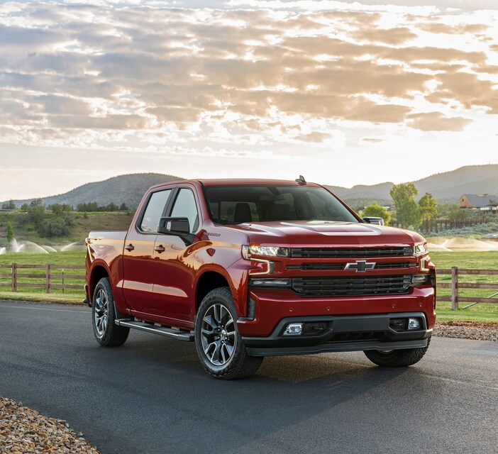 2020-Chevrolet-Silverado1500-RST-CrewCab-ShortBox-WheelAddOn-Truck-L01.png red Chevy Silverado truck parked next to a lawn being watered with sprinklers