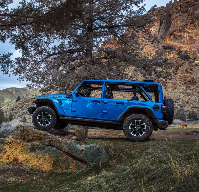 blue Jeep Wrangler parked on a ledge