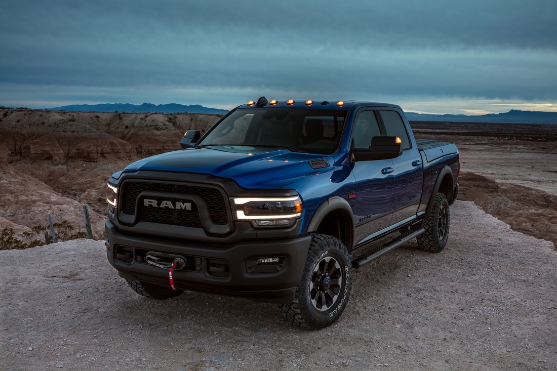 2022-RAM-2500-PowerWagon-CrewCab-Truck-L02.png dark blue Ram 2500 truck parked on a ledge