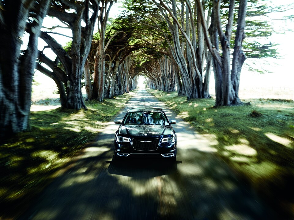 2017-Chrysler-300-300C-Sedan-L03.png black Chrysler 300 driving through a tree lined country road