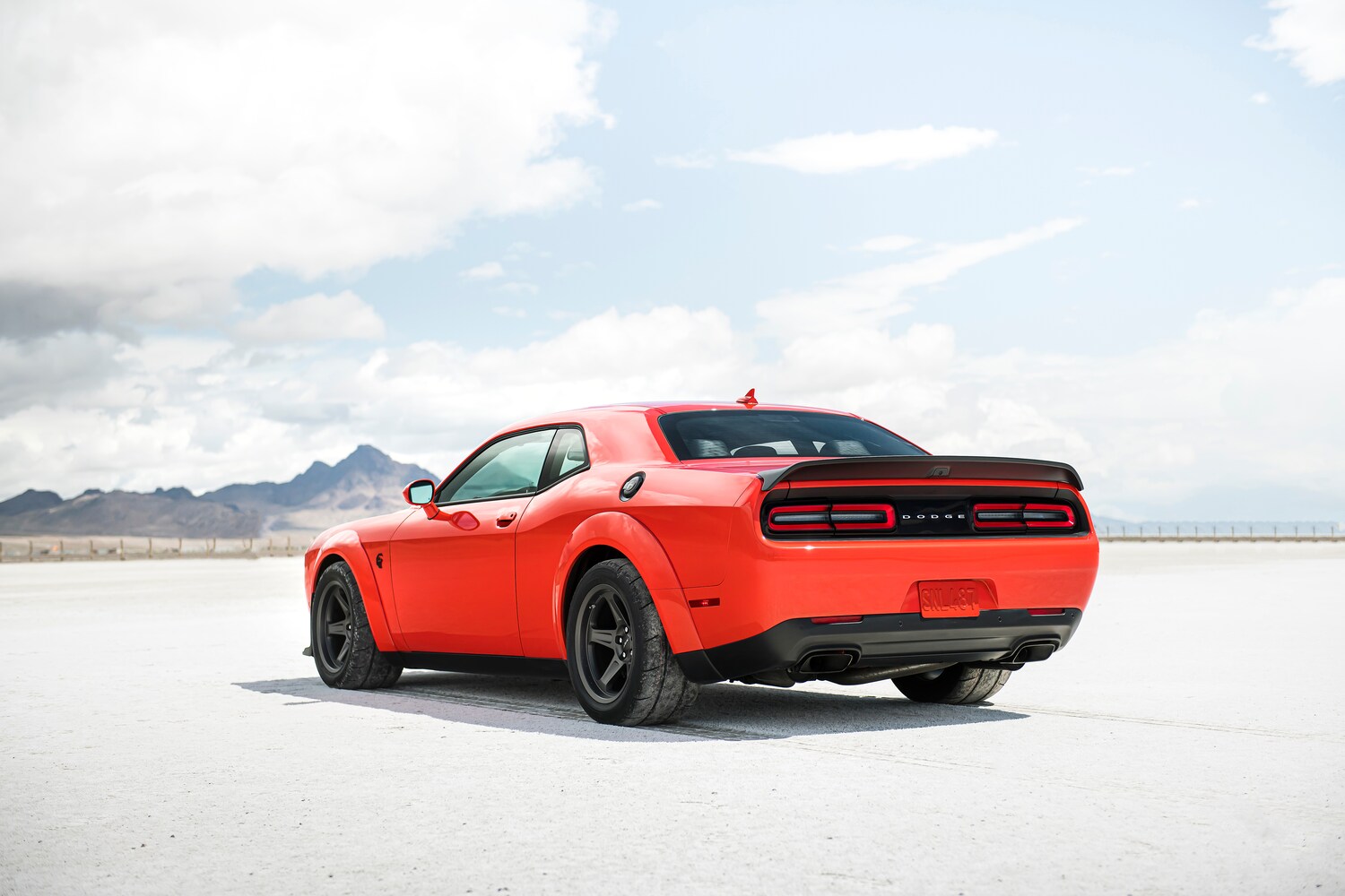 2021-Dodge-Challenger-SRTRedEye-Sedan-L05.png red Dodge Challenger Red Eye sedan rear view parked on a cement lined track