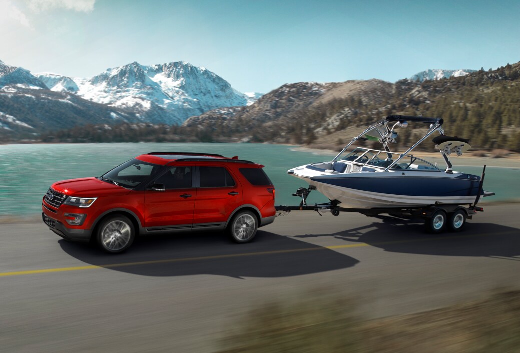 2017-Ford-Explorer-Sport-Crossover-L01 (2).png red Ford Explorer SUV driving past a lake, towing a boat