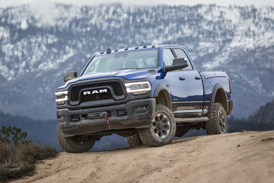 2022-RAM-2500-PowerWagon-CrewCab-Truck-L15.png blue Ram 2500 Power Wagon heavy-duty truck perched on a sandy hill