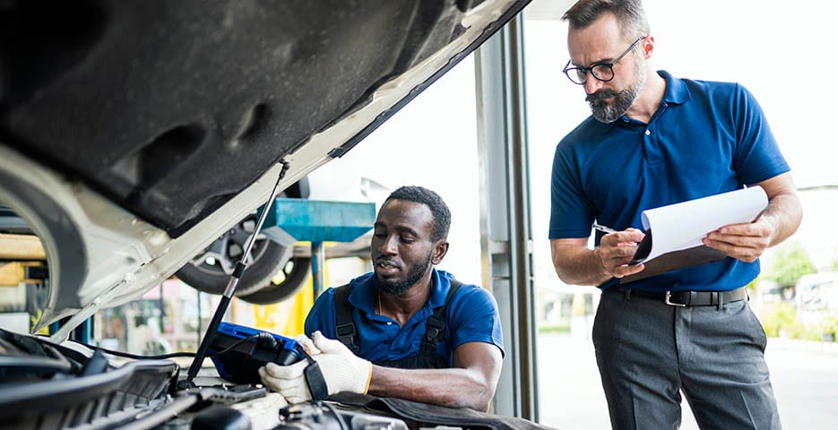 Protect your new vehicle with a Powertrain Warranty from Lithia Chrysler Dodge Jeep Ram FIAT of Spokane. Two service technicians diagnosing a vehicle issue.