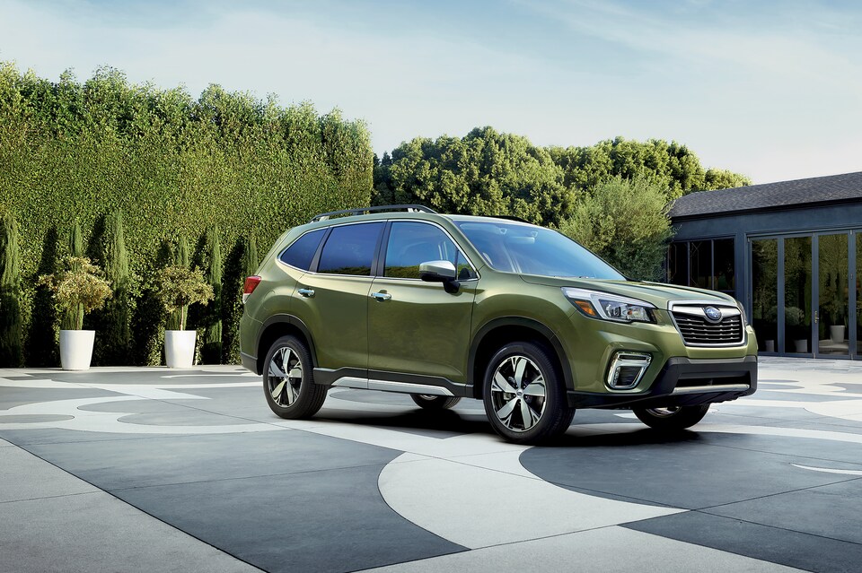 2020-Subaru-Forester-Touring-SUV-L01.png green Subaru Forester parked on a large terrace with surrounding shaped shrubs