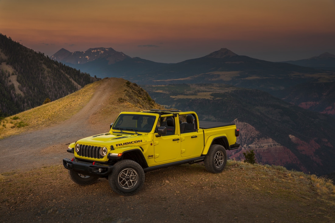 2024-Jeep-Gladiator-Rubicon-SUV-L10.png yellow Jeep Gladiator truck parked on a hill overlooking desert mountains