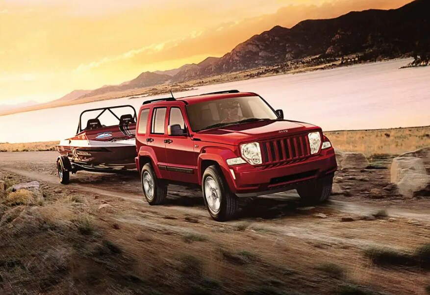 2012 Jeep Liberty.PNG red Jeep Liberty SUV towing a jet ski