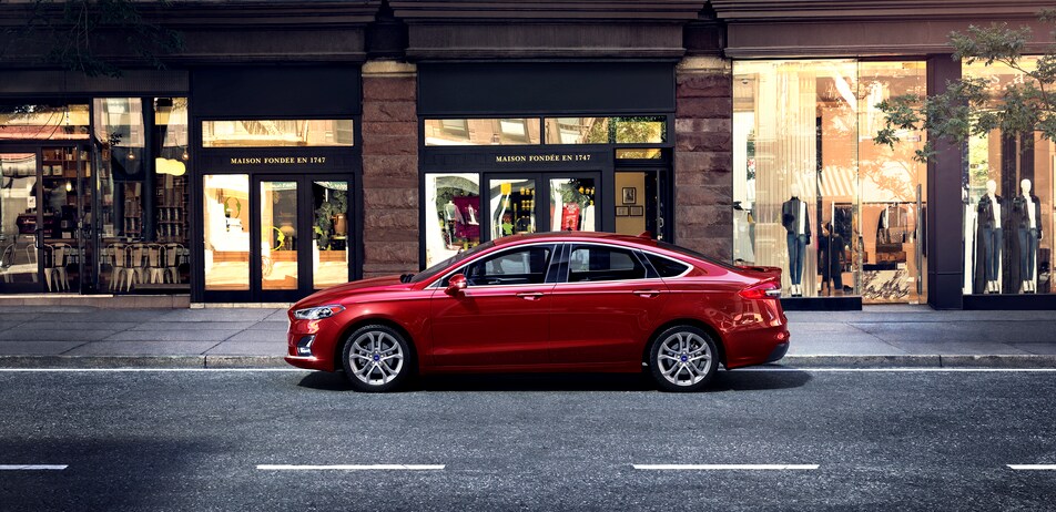2020-Ford-Fusion-SEL-Sedan-L01 (2).png red Ford Fusion sedan driving down city streets