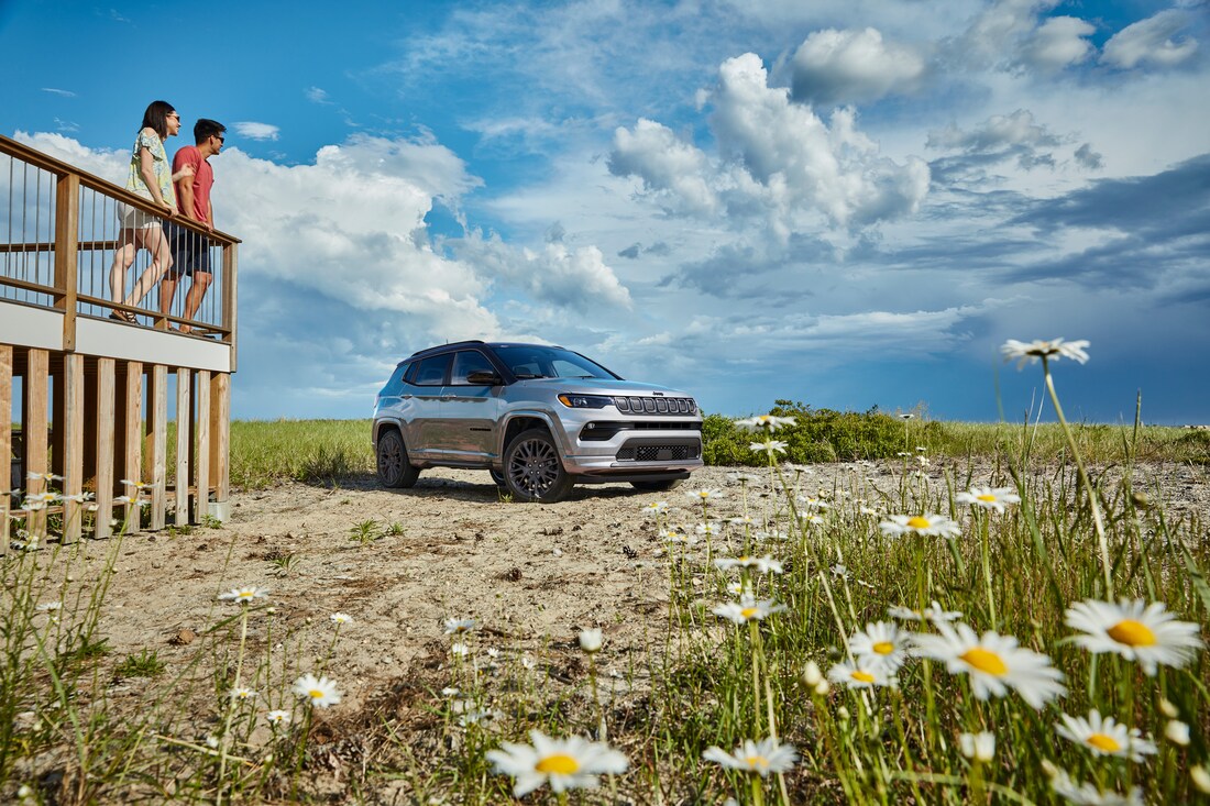 silver Jeep Compass SUV parked on the beach