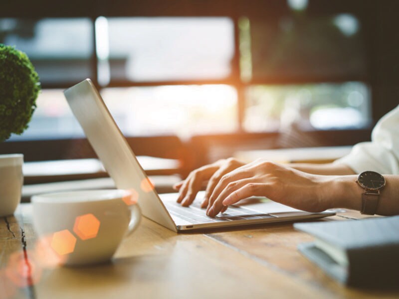 Tell Us About Your Vehicle. Person using a laptop on a table.