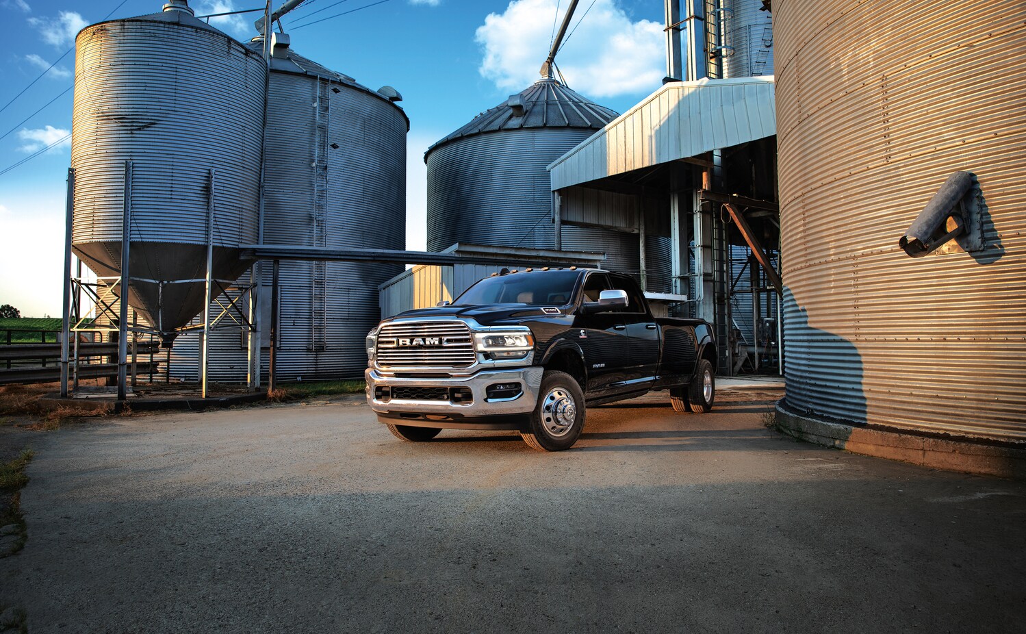 2021-RAM-3500-Laramie-CrewCab-Dually-Truck-L01 (3).png black Ram 3500 Laramie truck parked near a grain silo