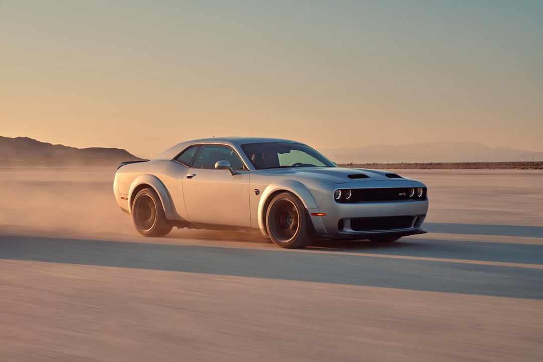 Dodge Challenger white Dodge Challenger driving in the desert