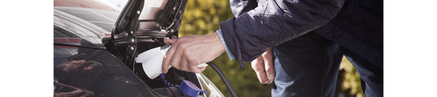 Plugging in an electric vehicle A person is plugging in an electric vehicle.