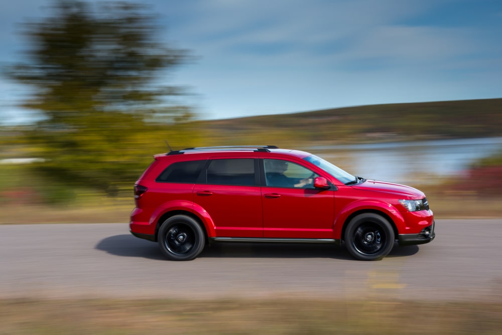 2021-Dodge-Journey-Crossroad-SUV-L06.png red Dodge Journey SUV driving near a lake