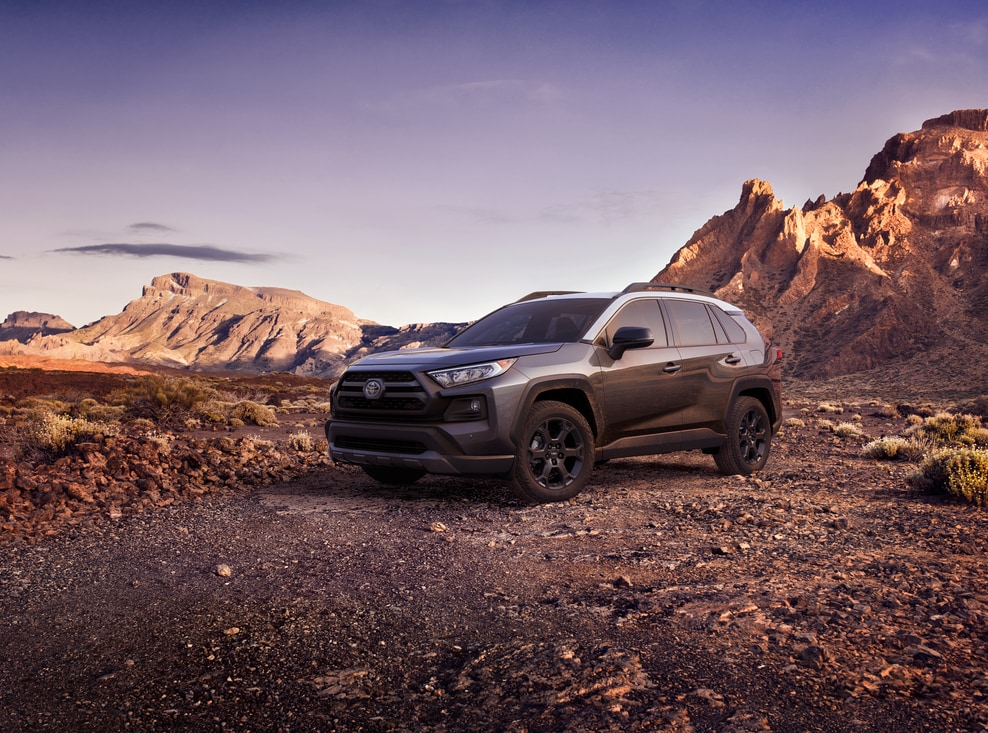 2023-Toyota-RAV4-TRDOffroad-SUV-L02.png dark grey Toyota RAV4 SUV parked in a red, rocky desert area