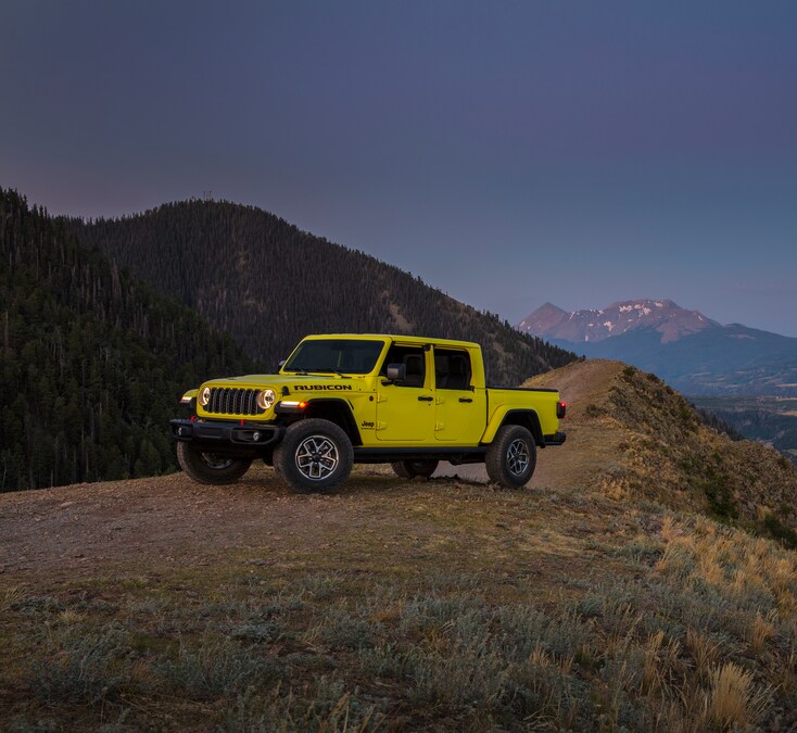 Jeep-Gladiator-Rubicon-truck-L07-1.png yellow Jeep Gladiator truck parked on a ridge overlooking desert mountains