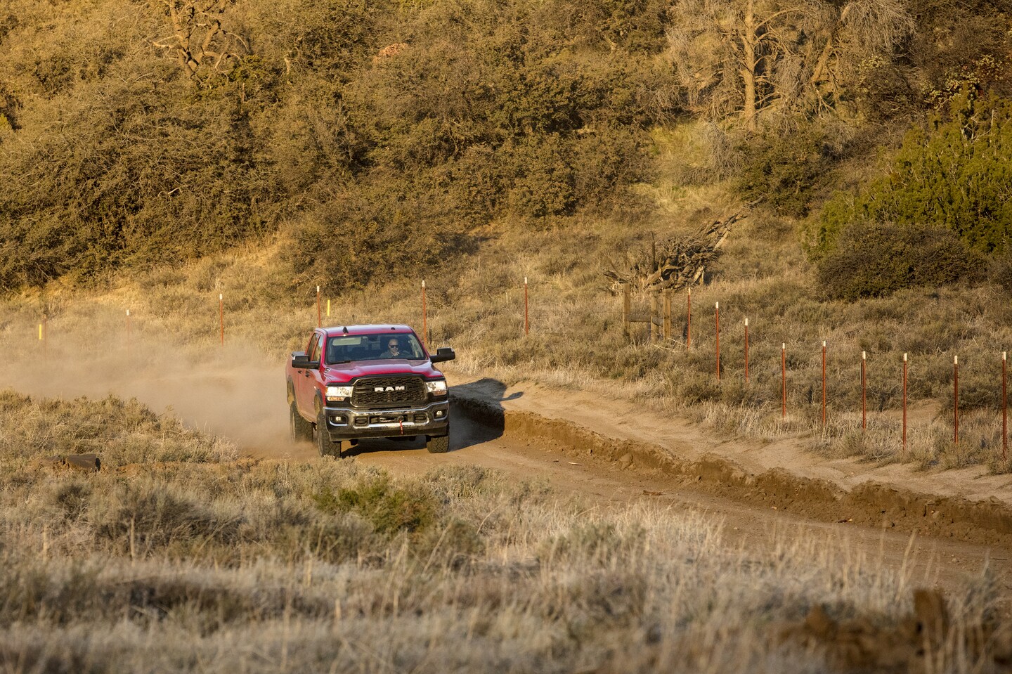 red Ram 2500 driving on a dusty, unpaved road
