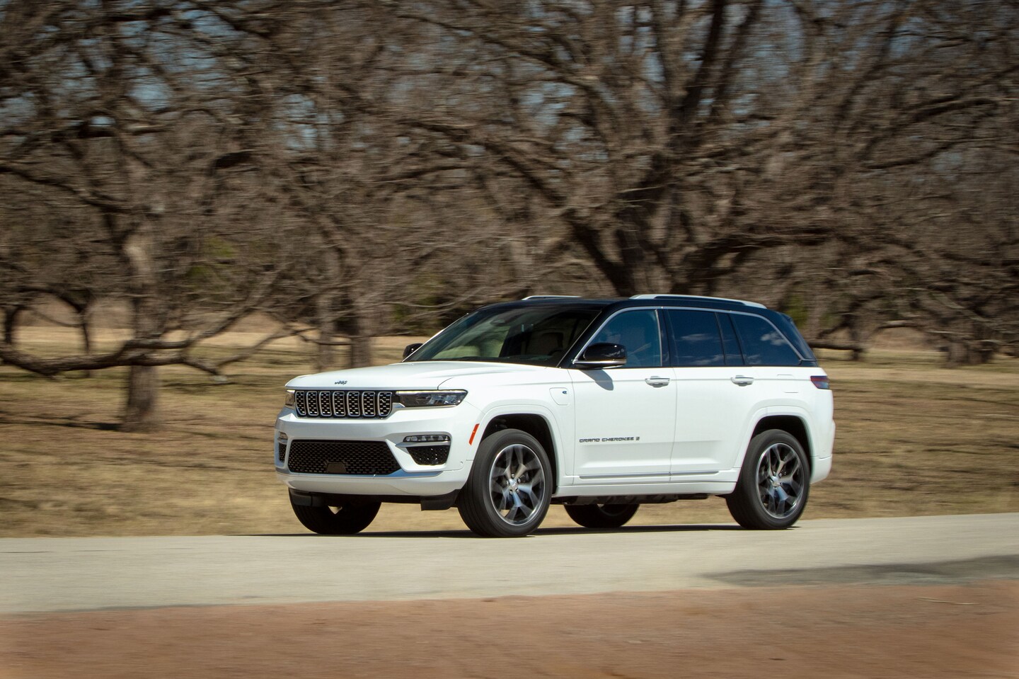 white Jeep Grand Cherokee driving through a desert area