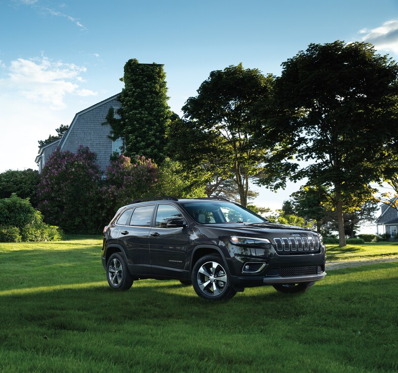 2023-Jeep-Cherokee-Limited-SUV.png black Jeep Cherokee SUV parked on a grassy field, in front of a farmhouse