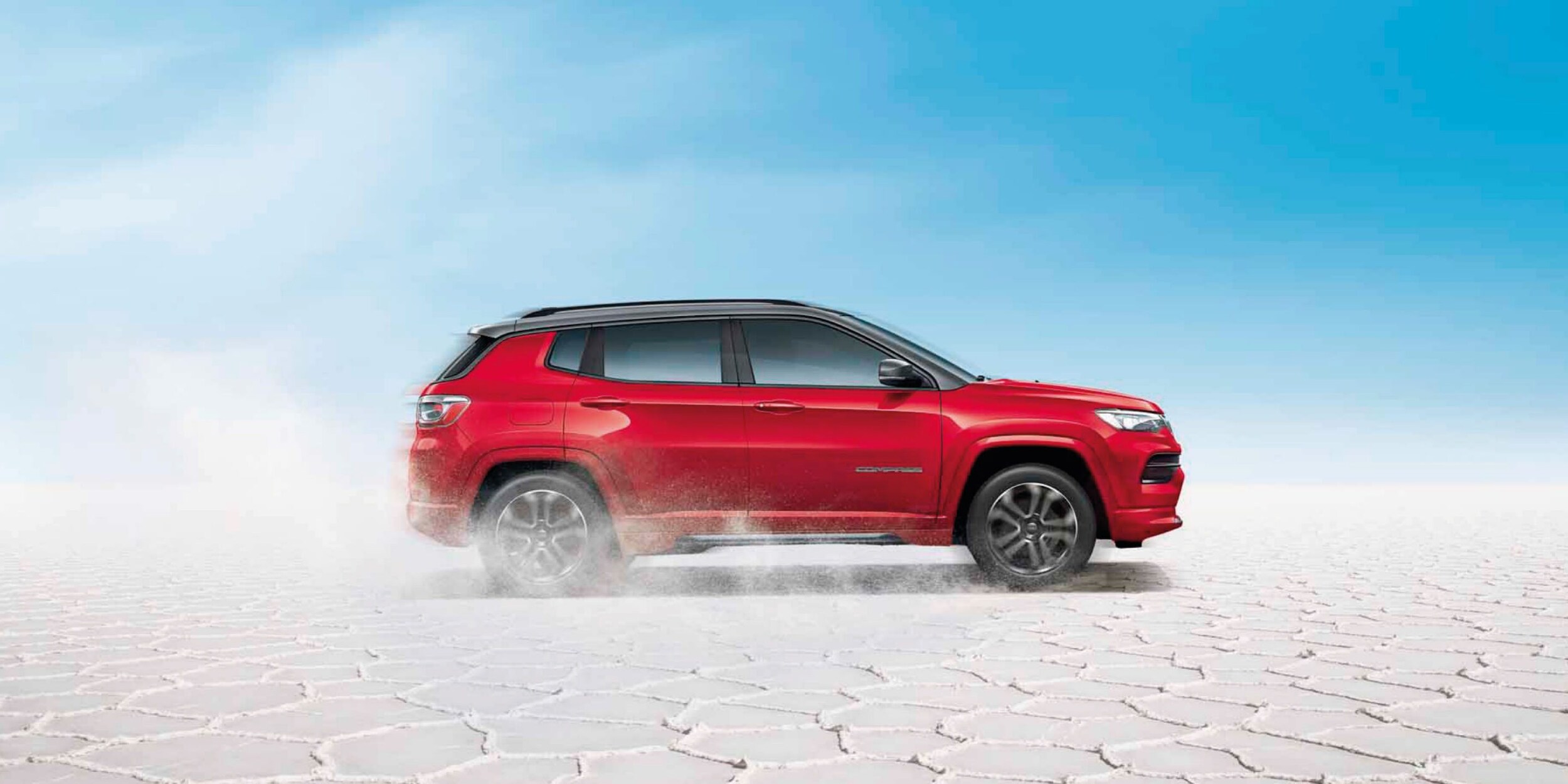 red Jeep Compass on a cracked desert