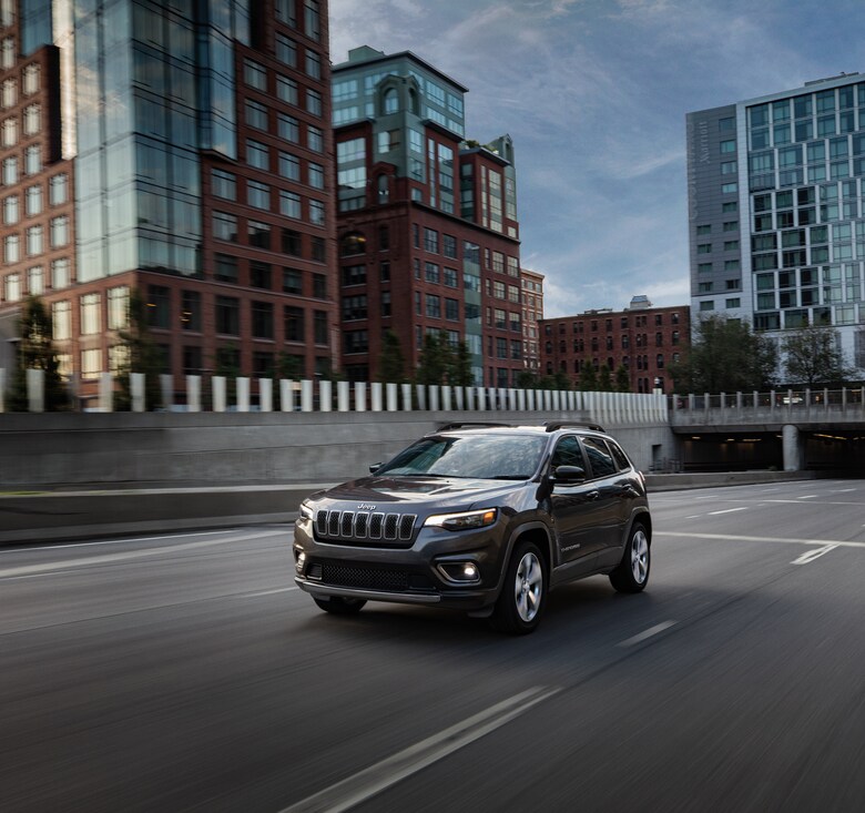 2023-Jeep-Cherokee-Limited-SUV-city.png black Jeep Cherokee SUV driving through the city