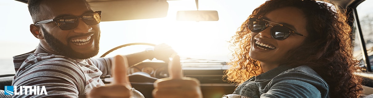 How to get the Best Deal on a Used Car Couple in a car putting a thumbs up