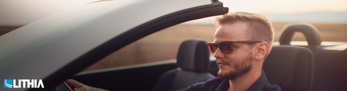 Luxury Used Car Bargains Young caucasian man driving a convertible