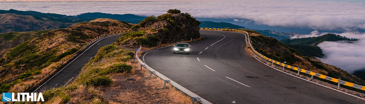 Pay as you Drive Car Insurance Car driving alongside a mountain hill