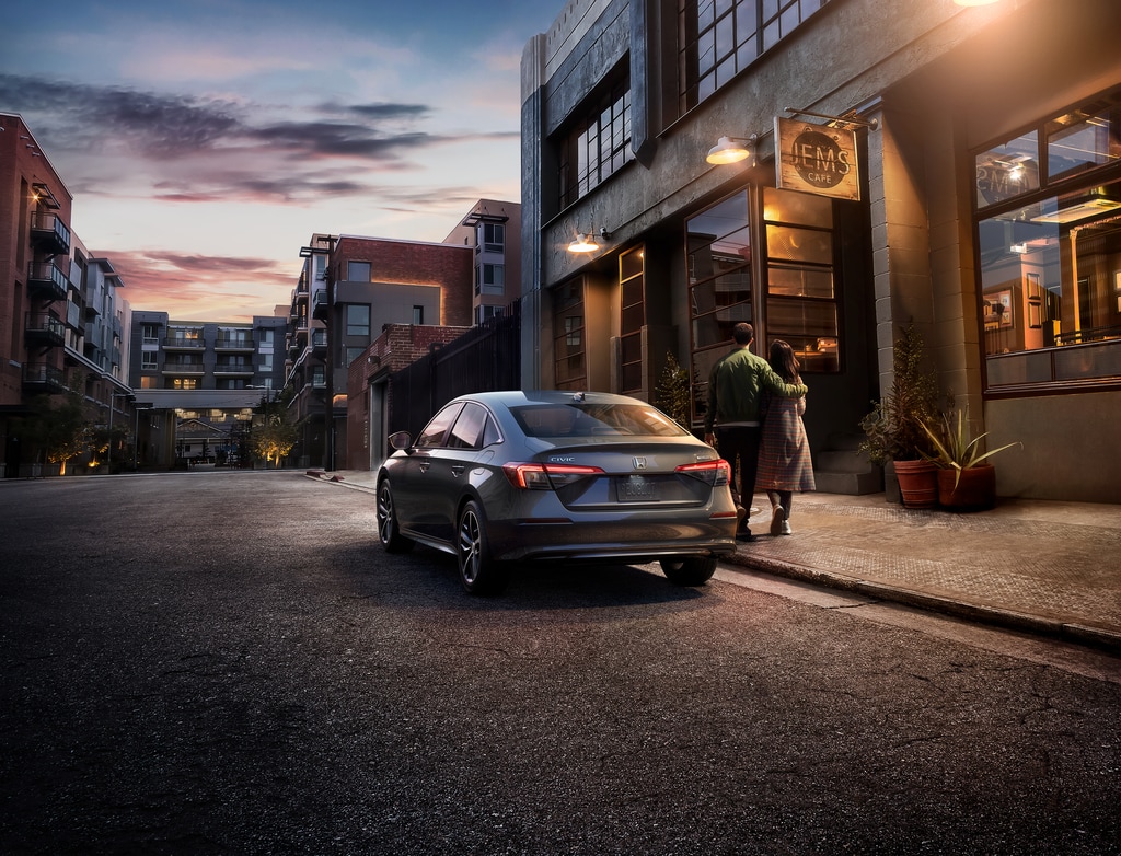 2022-Honda-Civic-Touring-Sedan-L03.png silver Honda Civic sedan parked next to a cafe with a couple walking by