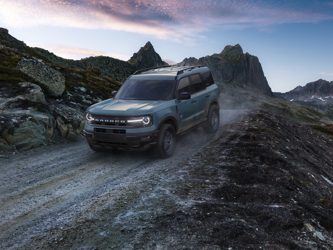 2024-Ford-BroncoSport-Badlands-4Door-SUV-L01.png blue grey Ford Bronco Sport SUV driving down a dirt hill