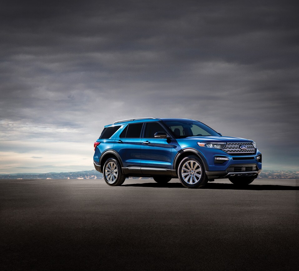 2020-Ford-Exporer-ST-SUV-L02 (2).png blue Ford Explorer SUV parked on an expanse of black with dark clouds covering the entire sky