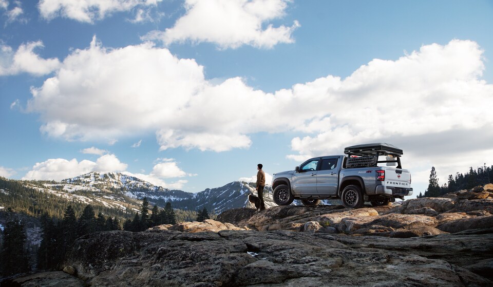 2022-Nissan-Frontier-PRO4X-CrewCab-Truck-L03.png silver Nissan Frontier truck on a rock ledge overlooking snow-capped mountains