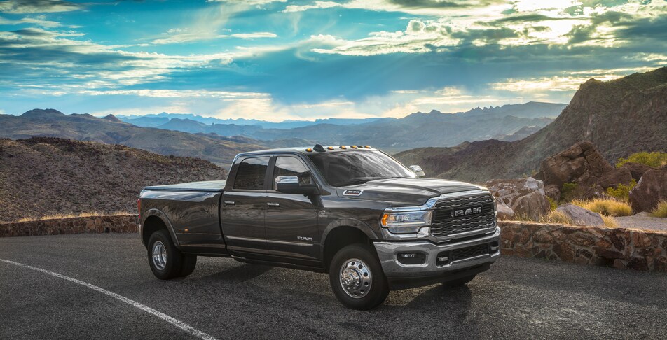 2021-RAM-3500-Limited-CrewCab-Truck-L03 (2).png dark brown Ram 3500 truck driving up a desert highway