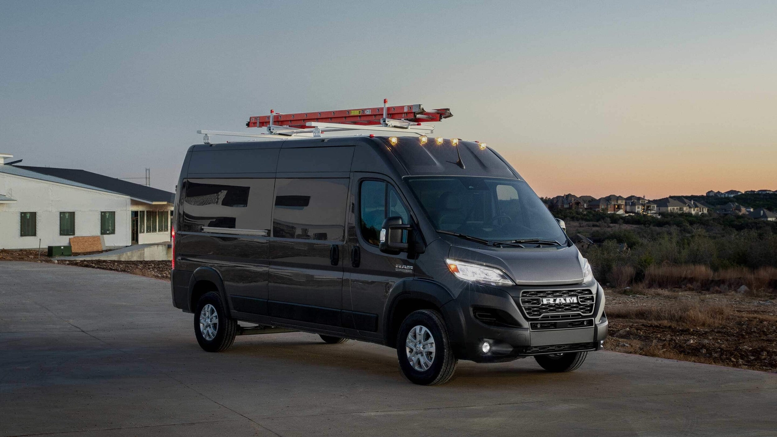 dark grey Ram ProMaster van leaving a new home construction site